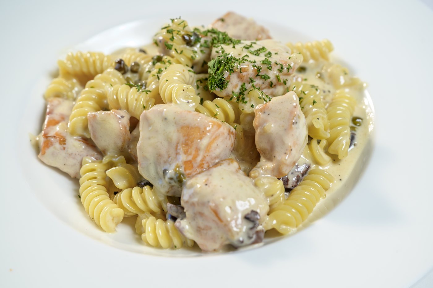Fusilli pasta with sauteed salmon, kalamata olives and capers in garlic cream sauce