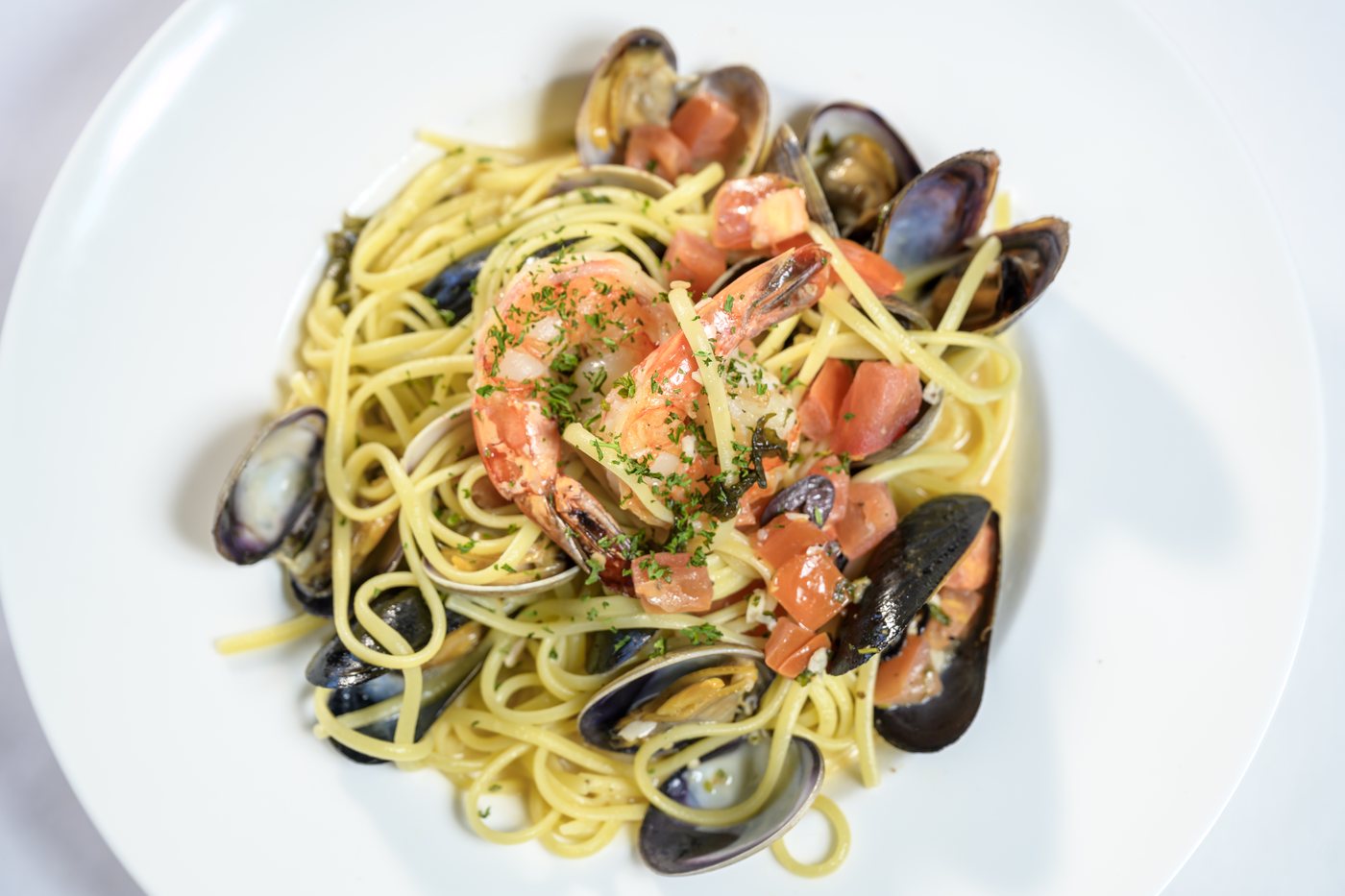 Linguine with prawns, mussels, clams and tomatoes in a herb white wine broth