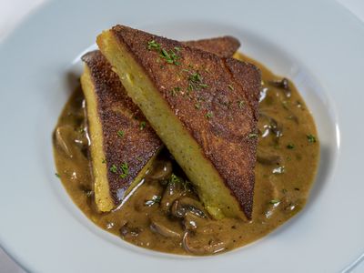Pan roasted polenta triangles in a wild mushroom brandy sauce