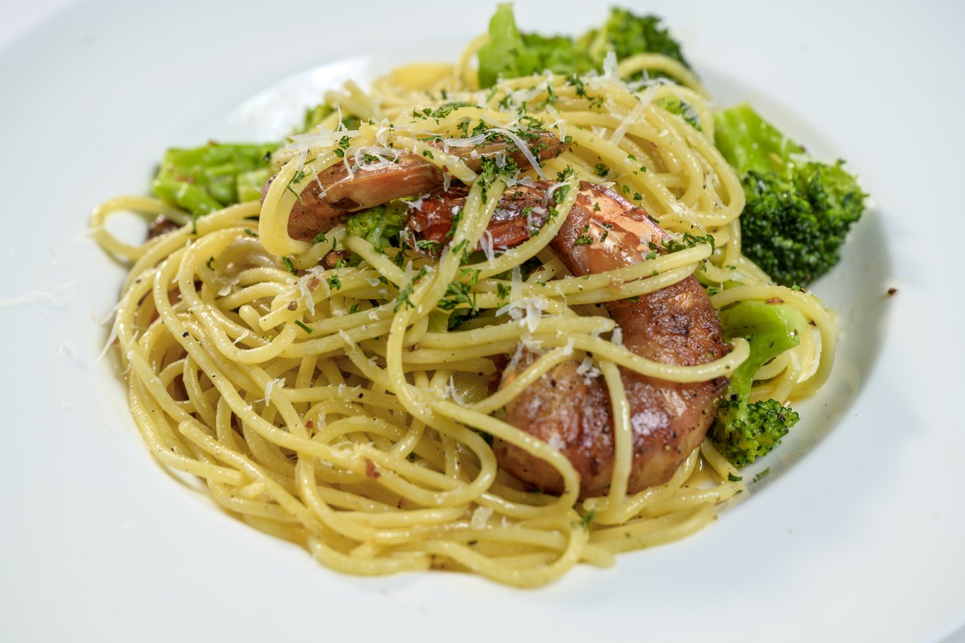 Grilled prawns wrapped in pancetta over spaghetti with broccoli and chili flakes