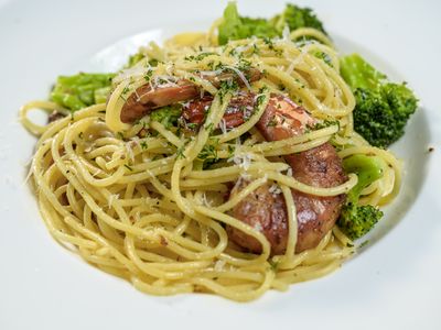 Grilled prawns wrapped in pancetta over spaghetti with broccoli and chili flakes