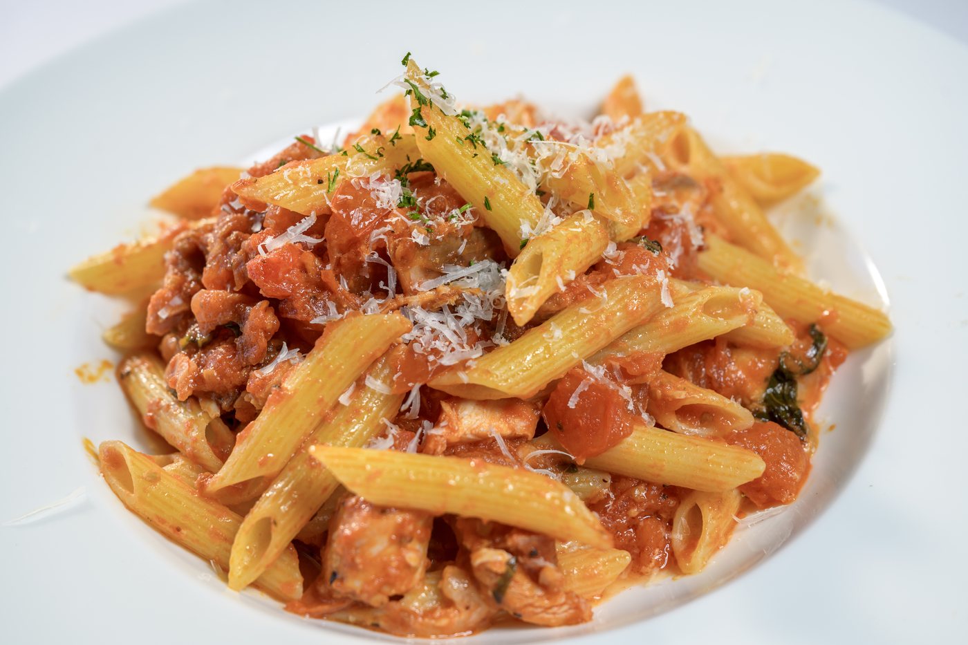 Penne with smoked chicken, marinated tomatoes and mozzarella in basil marinara