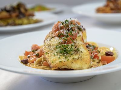 Fresh fish of the day over angel hair with tomatoes, olives and capers