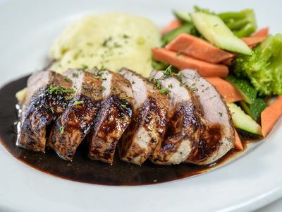 Grilled pork tenderloin with mashed potatoes, vegetables and balsamic chianti reduction