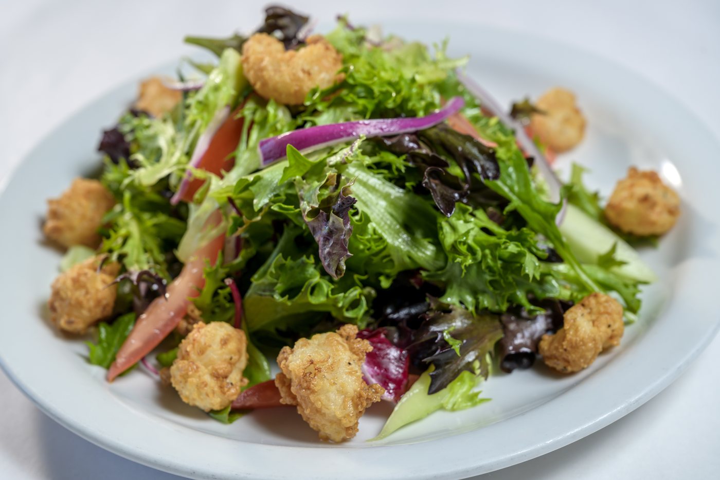 Rock shrimp salad with baby greens, red onion, tomato and cucumber