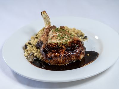 Bone-in pork chop over wild mushroom risotto