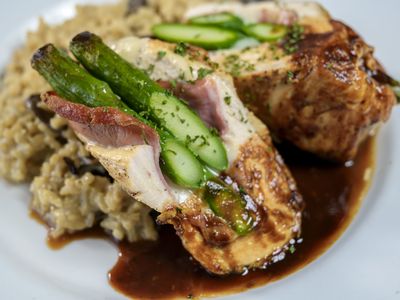 Chicken breast stuffed with prosciutto and asparagus over wild mushroom risotto