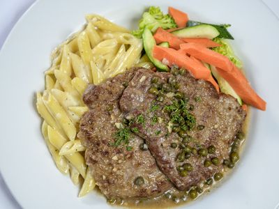 Pan seared veal with capers and lemon butter white wine sauce, penne alfredo and vegetables